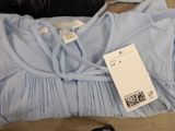 a blue dress with a tag on it on a couch