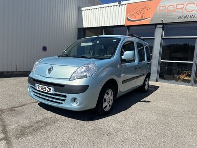 La petite camionnette bleue est garée devant un immeuble.