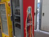 two soda coolers sitting next to each other in a building