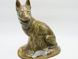 statue en bronze représentant un chien assis sur une surface blanche
