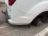 a white truck with a flat tire in a parking lot
