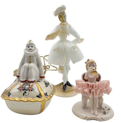 three figurines of a woman and a child on a plate
