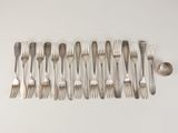 a lot of forks and spoons laid out on the table
