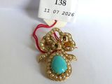 une photo d'un collier orné d'une pierre turquoise et de perles