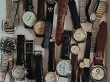 de nombreux modèles de montres exposés dans une vitrine blanche