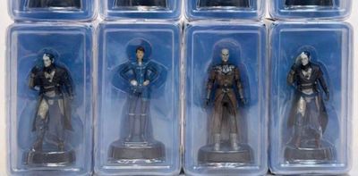 six action figures of a man in a suit in a box