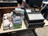 Plusieurs rouleaux de papier toilette sont posés sur une table à côté d'un ordinateur