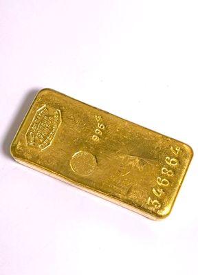 gros plan d'un lingot d'or sur une surface blanche