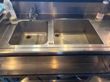 a stainless steel sink and a bottle of water on the counter