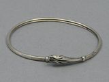 a close up of a silver bracelet with a knot on it