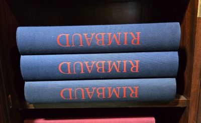 trois livres sont empilés les uns sur les autres sur une étagère