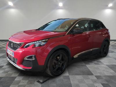 une voiture rouge est garée dans une pièce au sol en damier