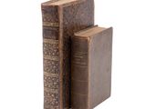 two books sitting on top of each other on a white surface