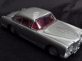 a silver toy car that is on a black background