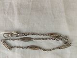 silver plated chain with a clasp and a clasp on a white cloth