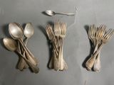 quatre fourchettes et cuillères sont disposées en rangée sur une table