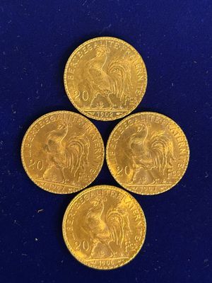 quatre pièces d'or sont disposées en triangle sur une surface bleue