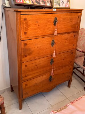 une commode sur laquelle est posée une télévision, à côté d'un fauteuil
