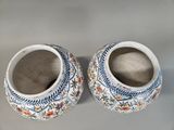 two vases sitting on top of a white table next to each other