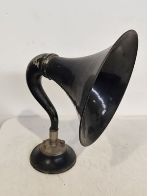 une enceinte rétro noire et argentée posée sur une surface blanche