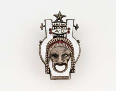 une image représentant une broche en argent sur laquelle figurent un visage et une étoile