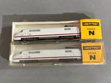 Deux trains miniatures sont posés dans une boîte sur une table