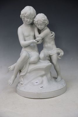 a statue of two children sitting on a rock