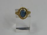 a close up of a ring with a blue stone in it