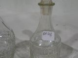 une bouteille en verre et une carafe en verre posées sur une table