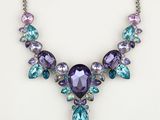 a necklace with purple and blue stones on a white background