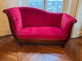 un canapé rouge posé sur un parquet