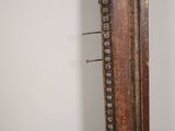 a mirror that has a wooden frame with rivets on it