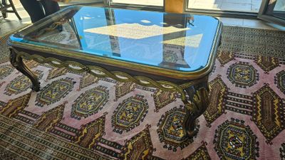 une table basse en verre avec un plateau en verre, posée sur un tapis