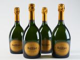 four bottles of champagne are lined up on a white surface
