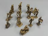 several brass figurines of various types and sizes on a white surface