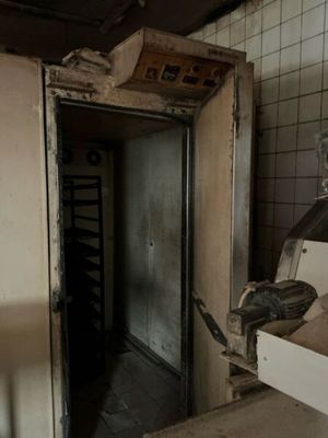an open door in a dirty kitchen with a dirty stove