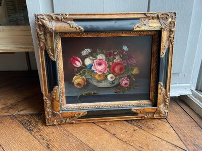 a picture of a painting of flowers in a vase on the floor