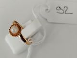 a close up of a gold ring with a pearl on it