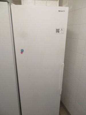 un réfrigérateur blanc dans un coin d'une petite pièce