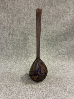 un petit vase muni d'une poignée en bois