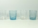 six verres de couleurs différentes alignés sur une table