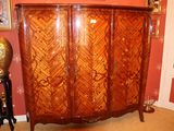 une armoire en bois dans une pièce où est accroché un tableau au mur