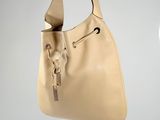 someone is holding a tan purse with a dog on it