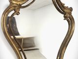un miroir doré accroché au mur d'une pièce