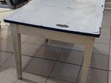 a white table with a blue top on a tiled floor