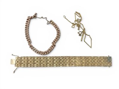 un gros plan d'un bracelet et d'une chaîne sur une surface blanche