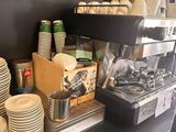 a coffee machine and cups on a counter in a coffee shop