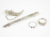 un stylo, une bague et un collier posés sur une table