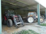deux tracteurs garés dans un garage, l'un derrière l'autre