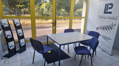 une table et des chaises dans une pièce avec une grande fenêtre